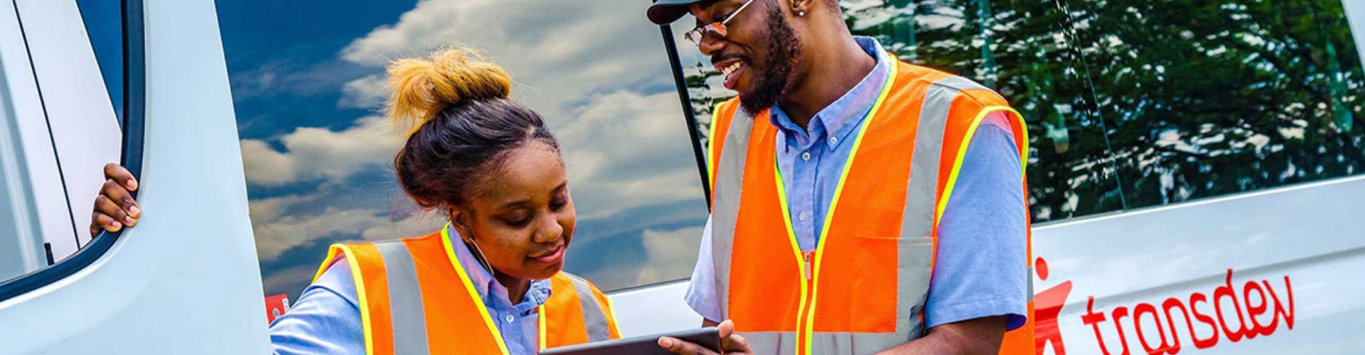 two operations managers wearing orange vests and discussing a topic