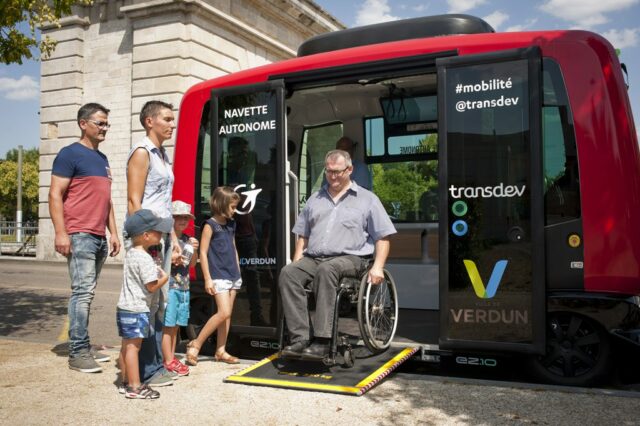 Transport navette autonome rouge Verdun homme descendant seul sans difficulté en fauteuil roulant