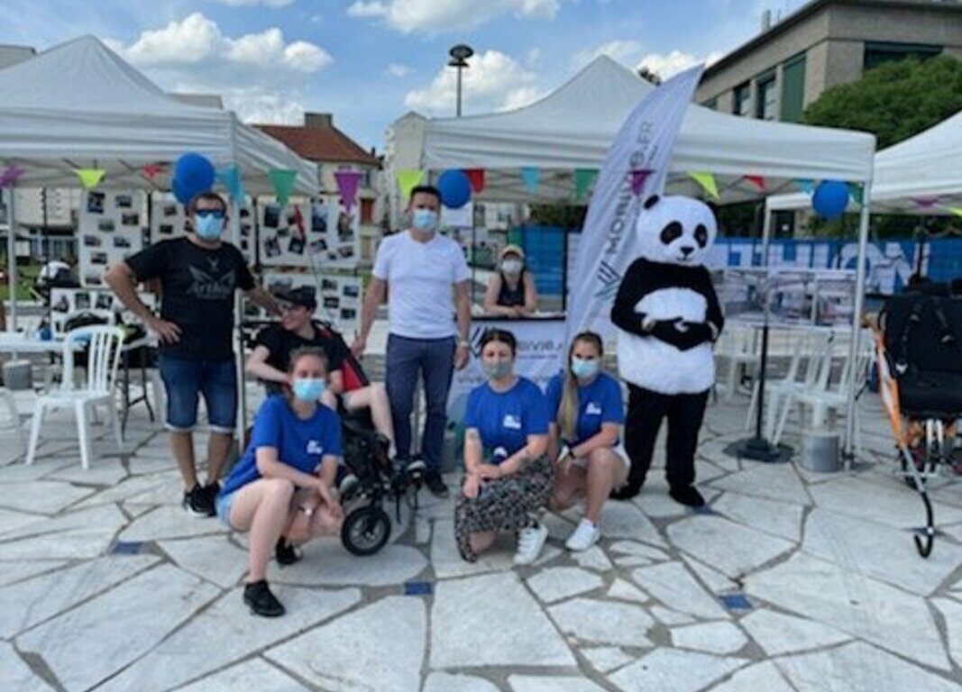 photo lors de la nuit de l'handicap entre salariés, mascotte et enfants handicapés