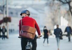 Homme à vélo de dos avec un casque et un pull rouge