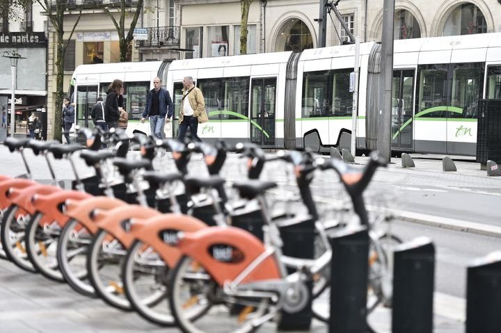 vélo en libre service sur Nantes en premier plan et un bus vert en arrière plan
