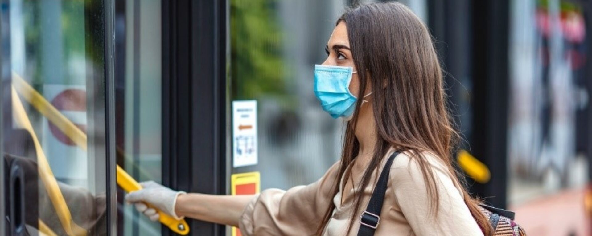 Jeune femme masquée qui monte dans un bus