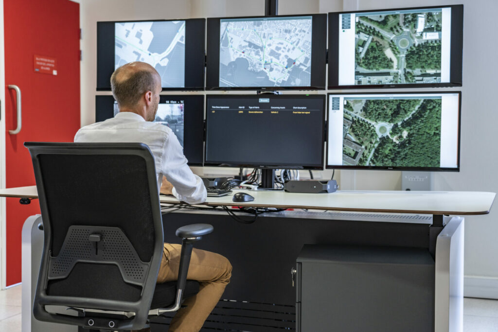 Homme assis devant les écrans de Supervision de flottes de véhicules autonomes