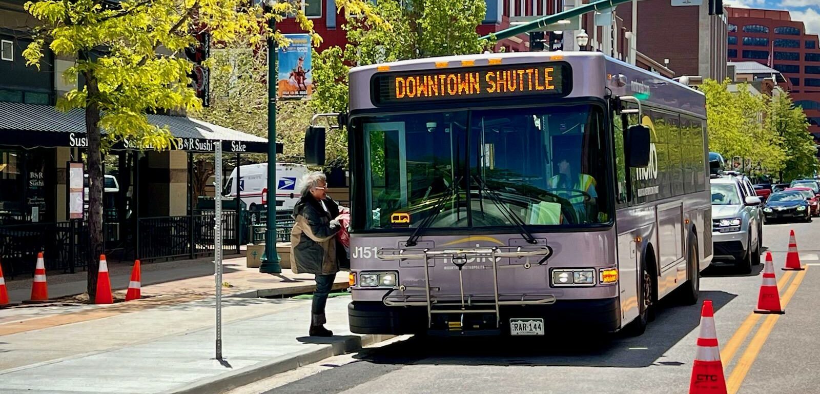 Bus violet USA en direction de Downtown Shuttle femme attendant de monter à bord route travaux