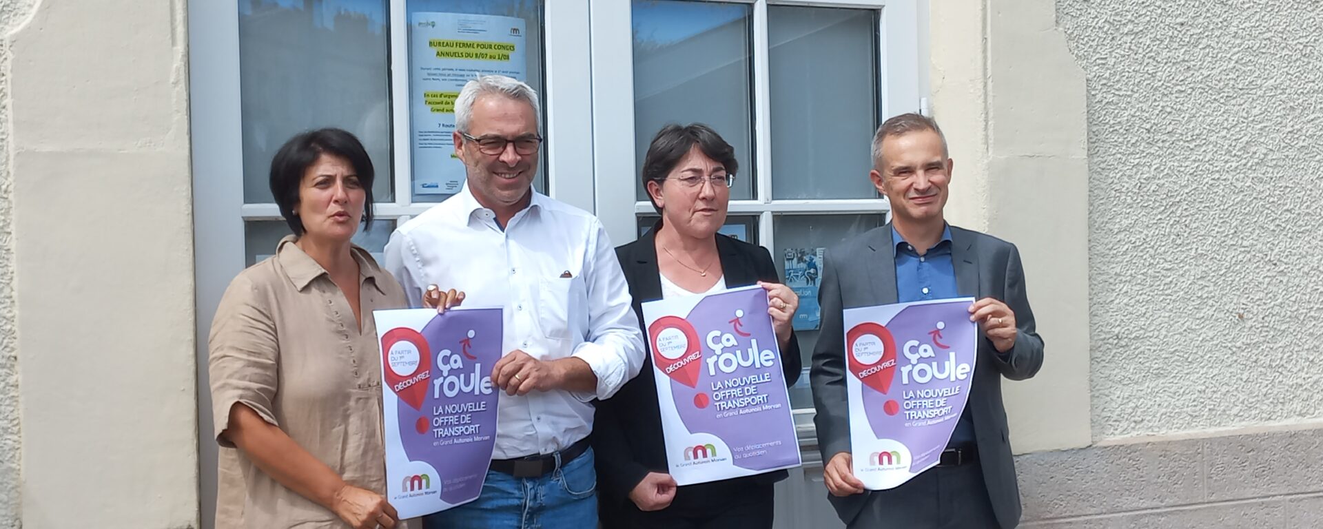 Transdev Bourgogne Franche Comté : 2 hommes et 2 femmes tiennent des affiches "ça roule", le nouveau réseau de transport