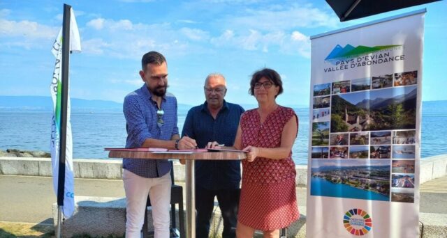 2 hommes et une femme debout devant un kakemono Pays d'Evian signent le partenariat Transdev réseau eva’d à Evian sur une table haute