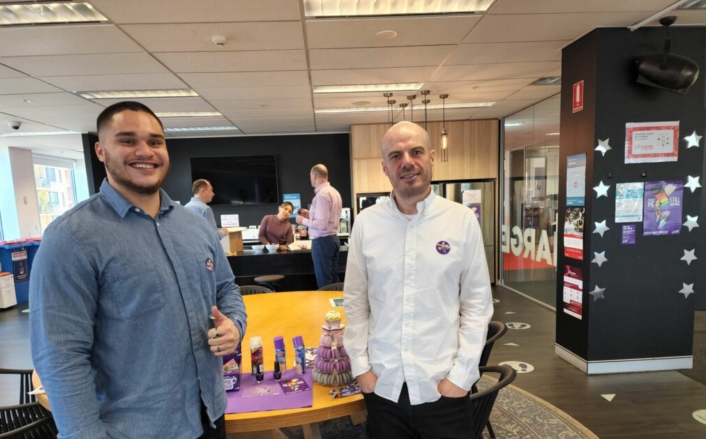 2 men standing and wearing a Wear it purple day pin on their shirts in Australia