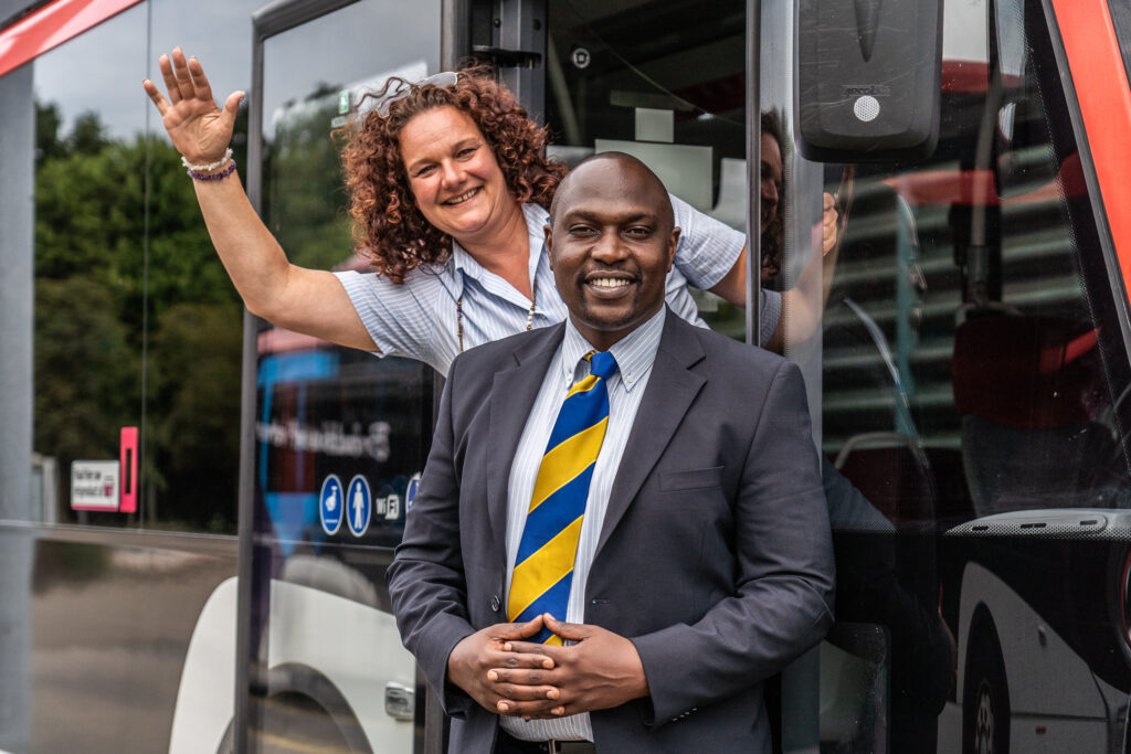 Bus drivers Ronnie and Chatal smiling in font of their bus in The Netherlands