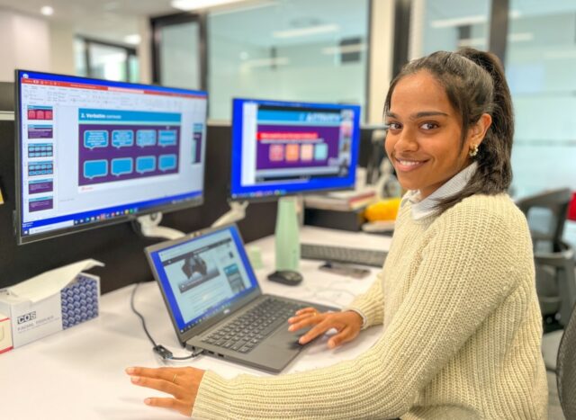 Christine Joshua sitting in front of her computer at Sidney Ferries