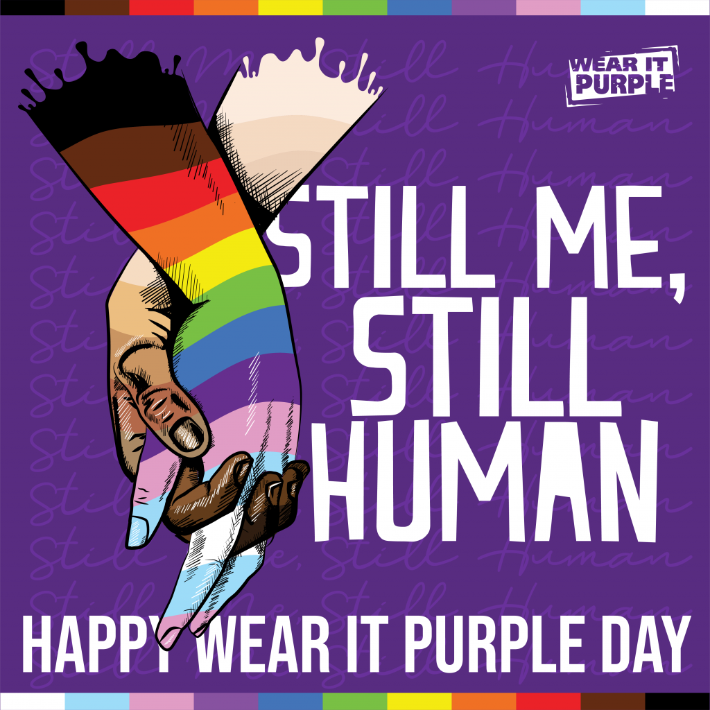 Wear it purple Day posters : two hands (one rainbow color, the other mixing several races) are holdong. The text is as follows : Still Me, Still Human Happy wear it purple day