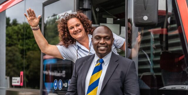 Bus drivers Ronnie and Chantal smiling in front of their bus in the Netherlands