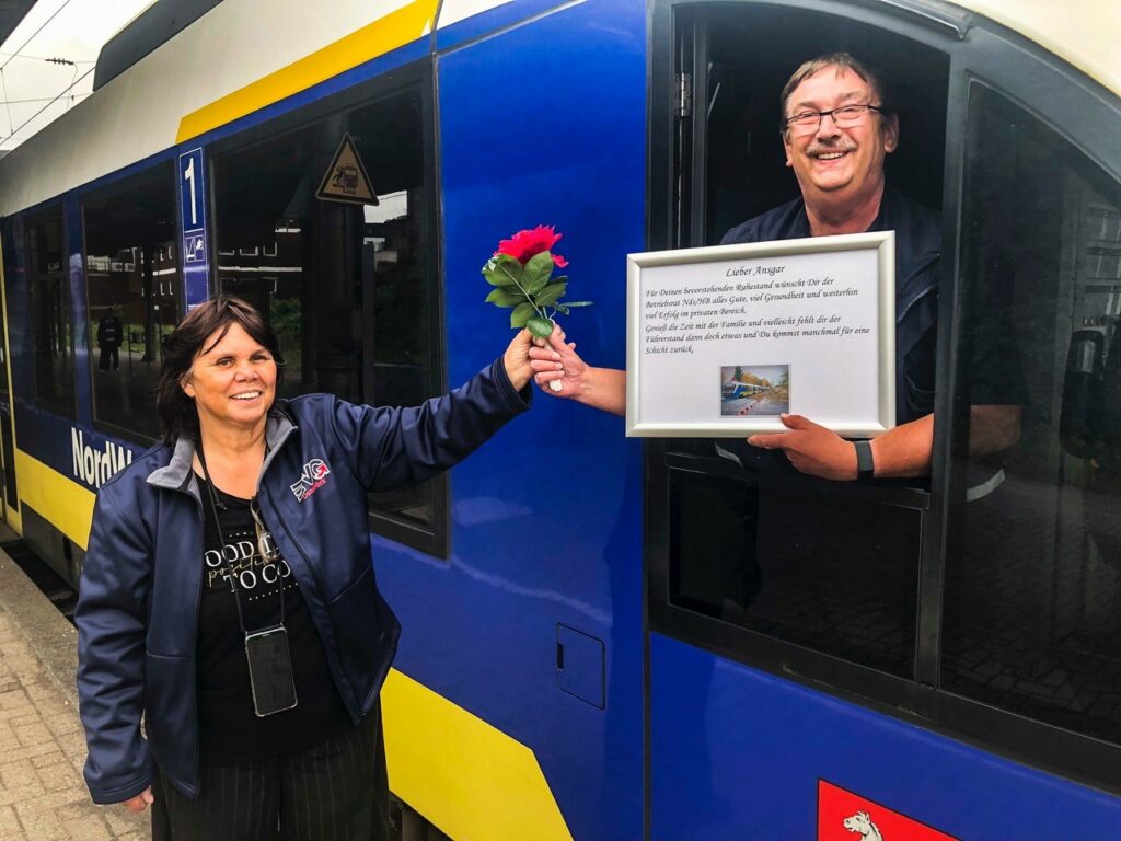 Uta Ehlert giving an award and flowers to a train driver in his train