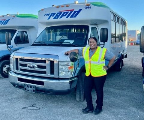 woman standing in front of a “The Rapid’s” vehicle