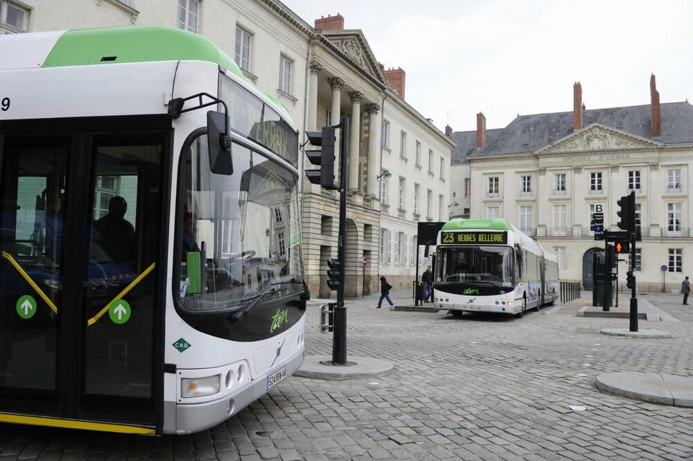 Bus vert et blanc TAN dans Nantes vers Perray et Bellevue sur rue pavée