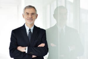 portrait de thierry malet en costard se tenant devant une vitre