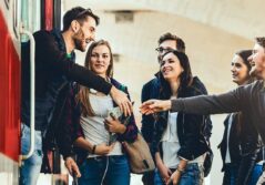 Plusieurs jeune à une station de métro, un homme sert la main à un autre homme