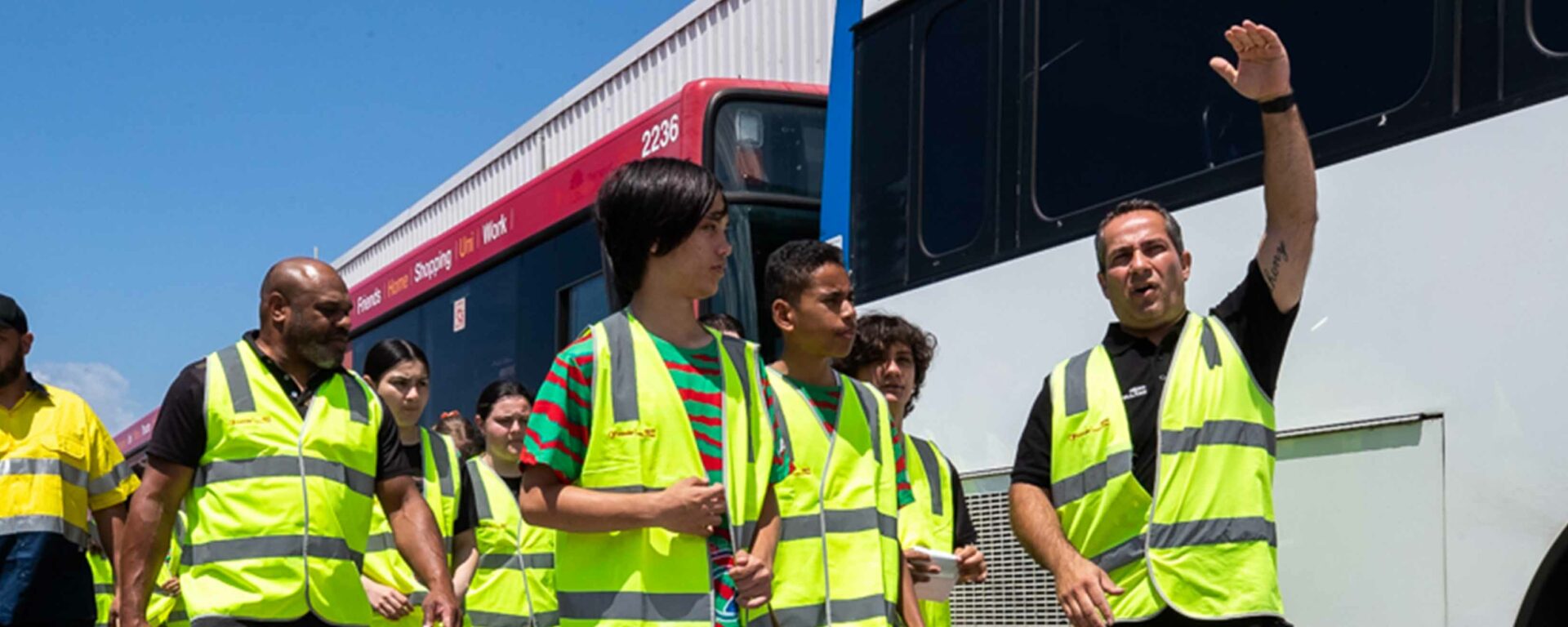 Sydney local youth with yellow safety jackets in front of a bus