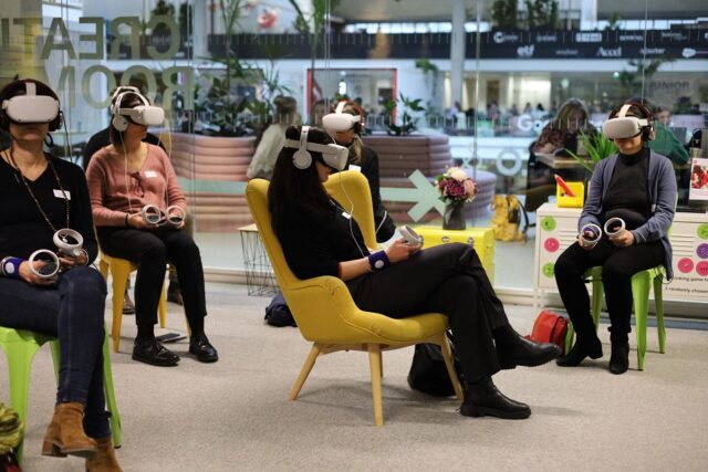 Groupe de personnes assises qui testent des casques VR (virtual reality/réalité virtuelle)
