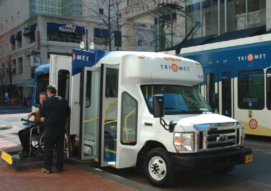 Man sitting on a wheelchair boarding a trimet vehicle