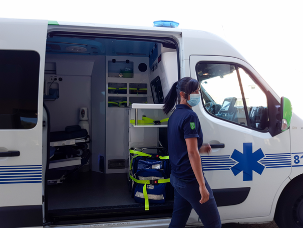 Ambulancière qui porte un masque devant une ambulance Carius