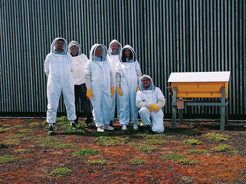 Groupe de personnes en tenue d'apiculteur