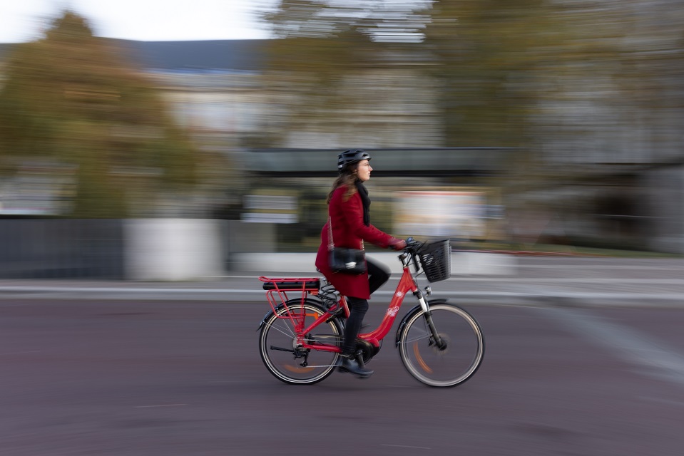 Femme qui pédale un vélo rouge